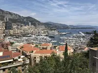 View of Monaco bay with mountains in the background, and boats moared up